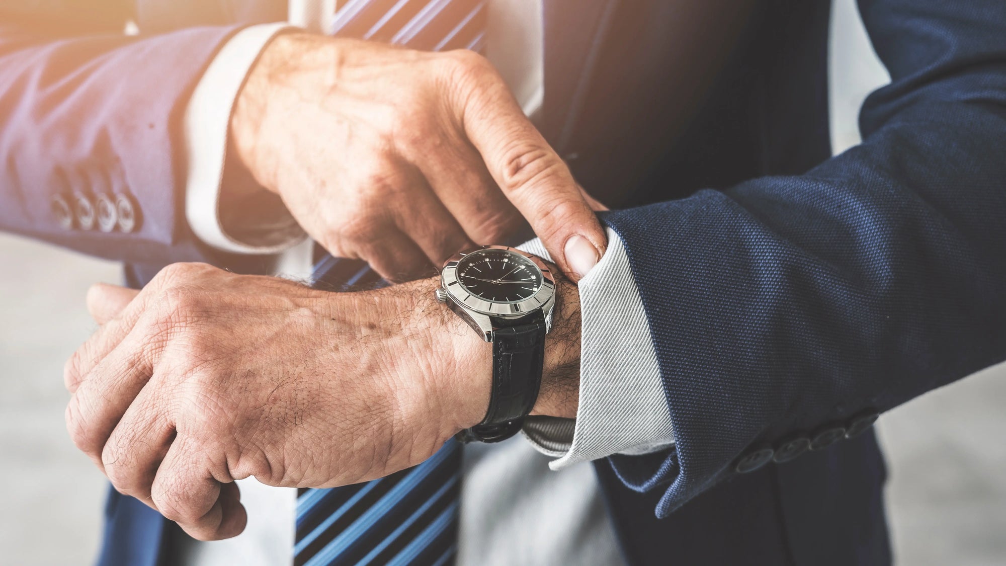 professional man in suit and tie checking his watch