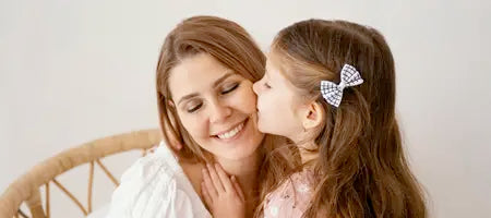 daughter kissing mother on the cheak