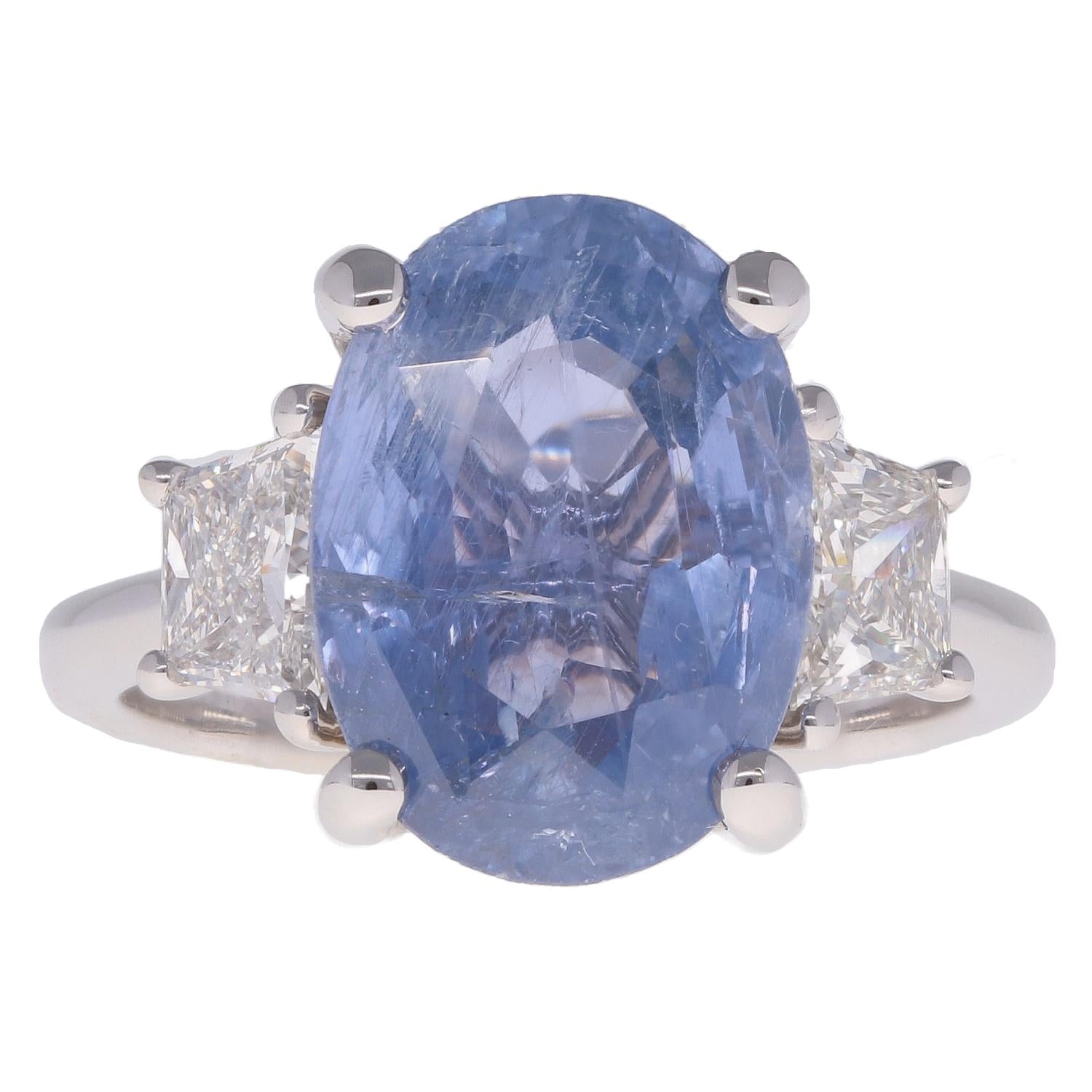 Ring with a blue gemstone and two smaller diamonds on a white background