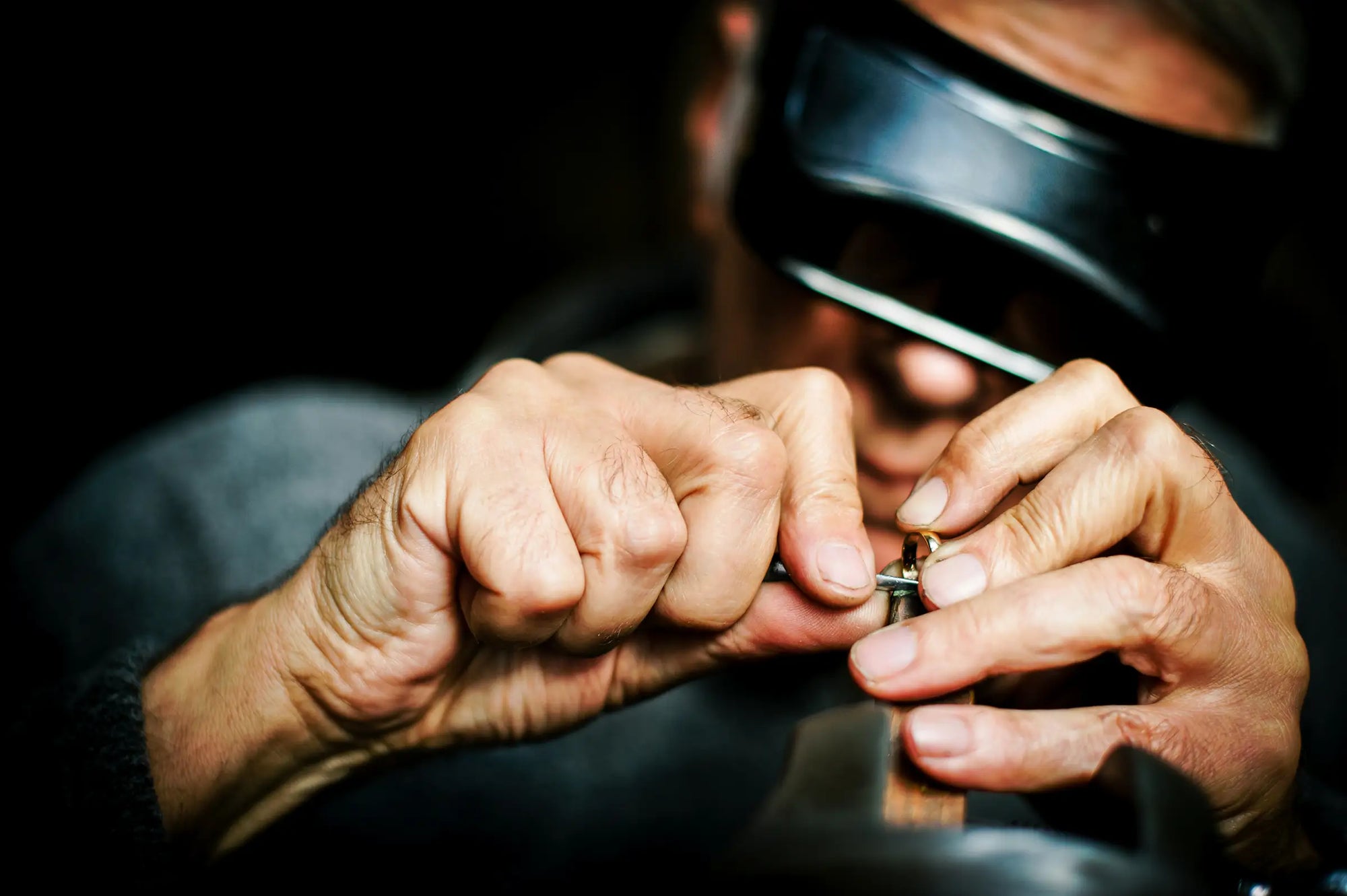 jeweler examining and repairing a ring