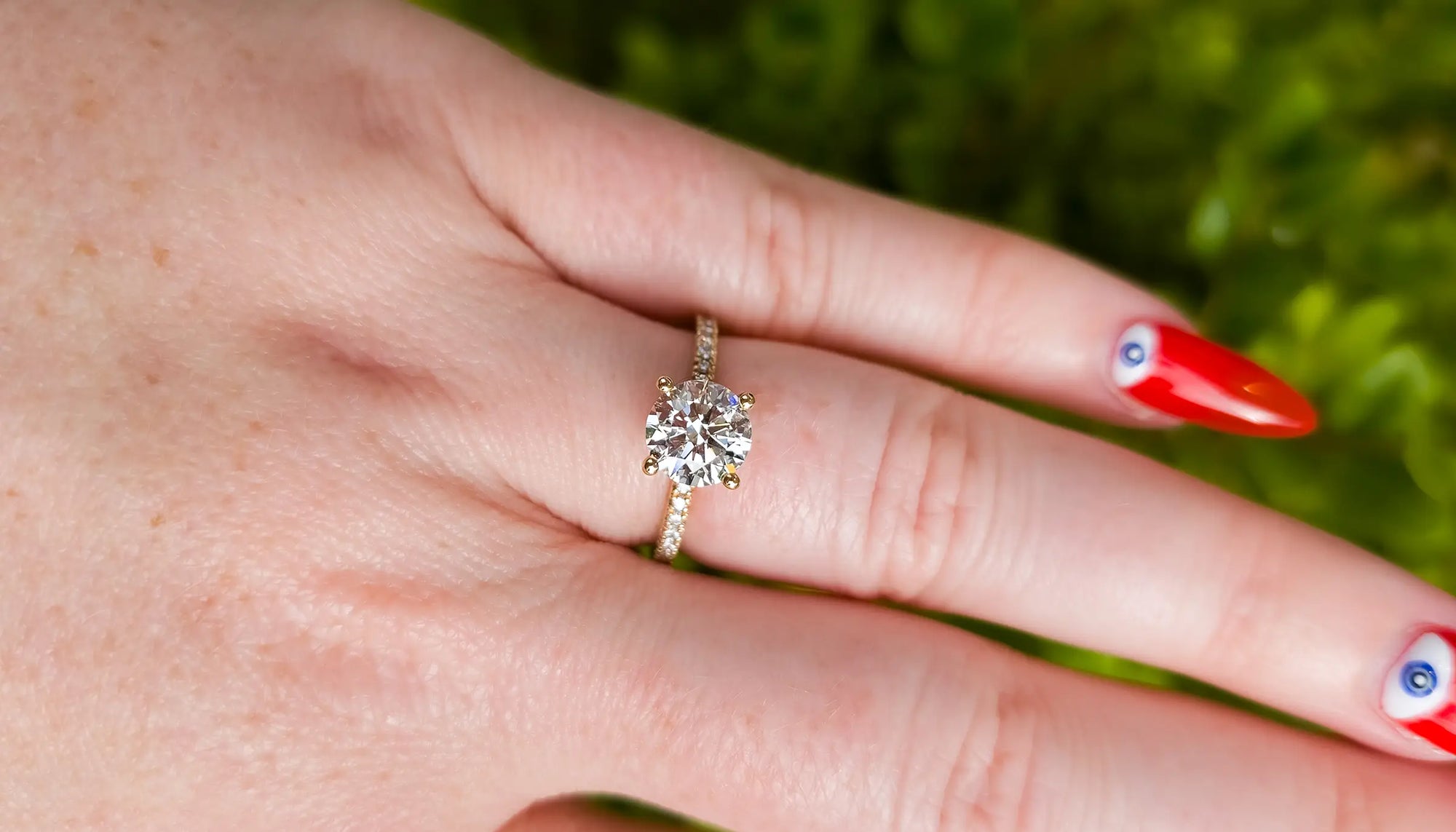 Close-up of a hand wearing a round diamond ring with an accented band 