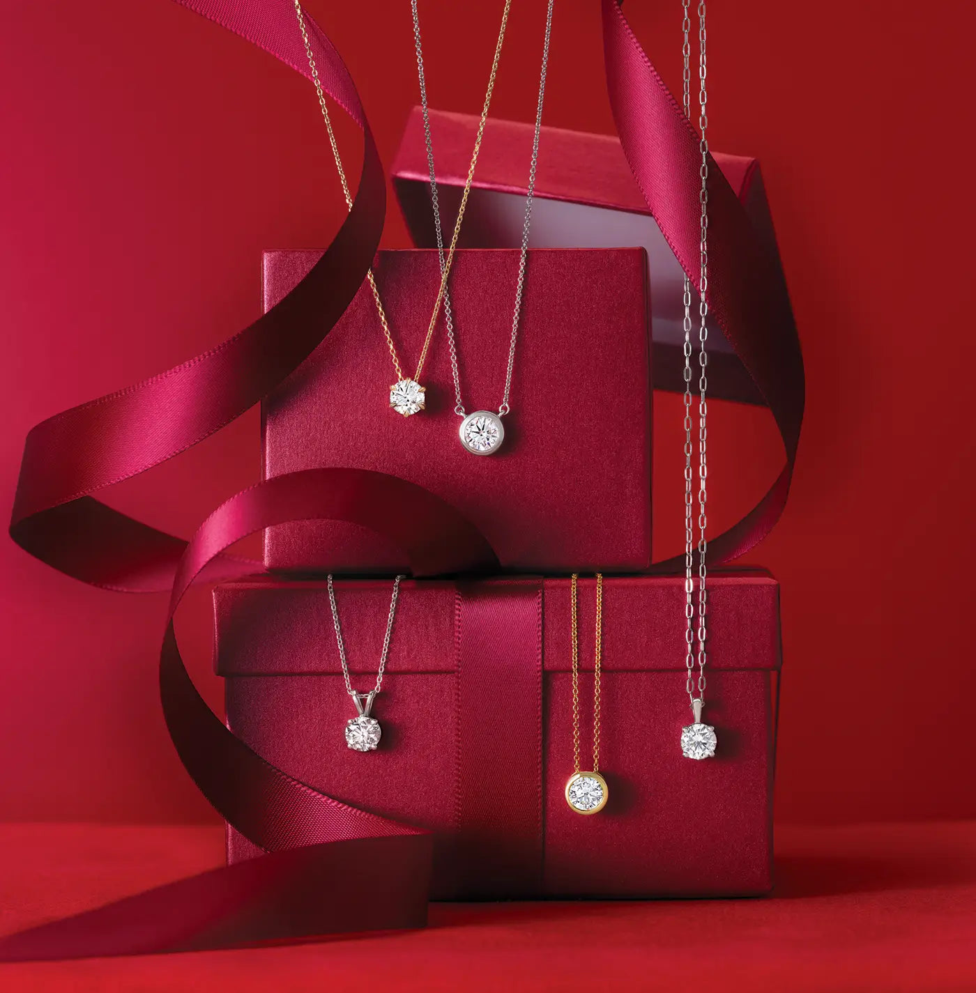 Diamond necklaces on red jewelry boxes with a red background